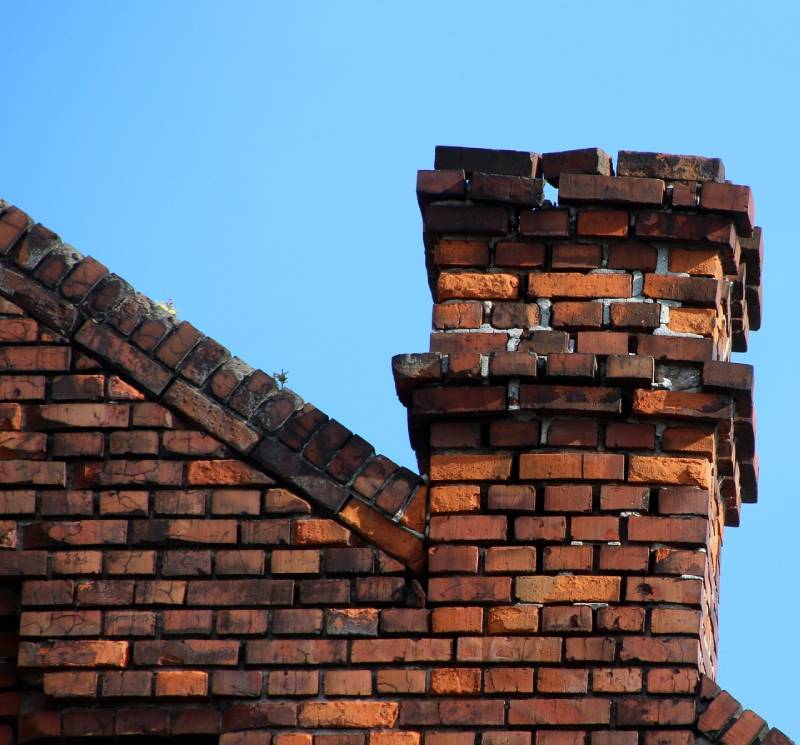 Signs Your Millbury Home Needs a Chimney Inspection Damaged chimney on an Millbury home showing cracks and missing mortar